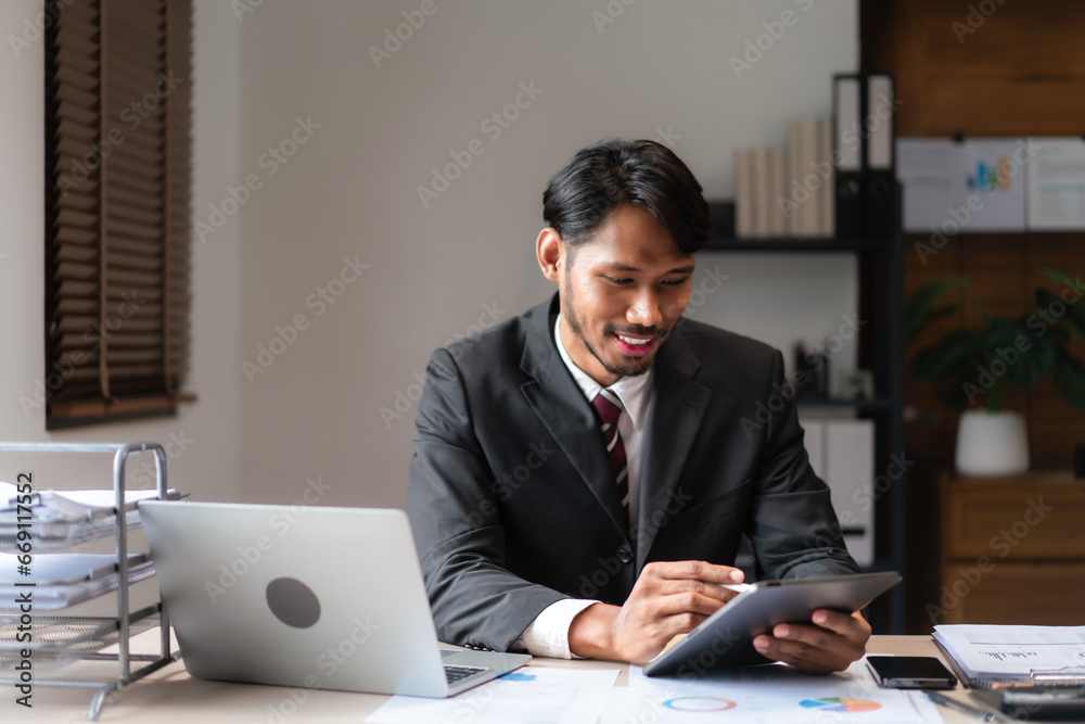 Businessman writing business data on tablet while analyzing strategy of startup business project Businessman writing business data on tablet while analyzing strategy of startup business project