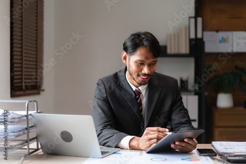 Businessman writing business data on tablet while analyzing strategy of startup business project