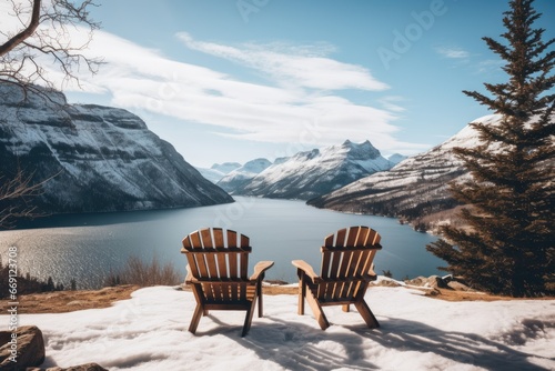 A pair of wooden chairs overlooking lake