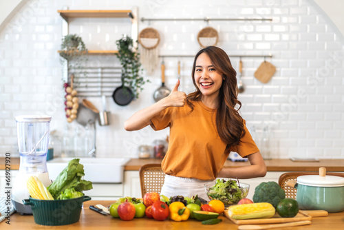 Portrait of beauty body slim healthy asian woman having fun cooking and preparing vegan food healthy eat with fresh vegetable salad, vegetarian on counter in kitchen at home.Diet.Fitness, healthy food © Art_Photo