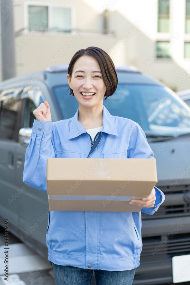 荷物を運ぶ笑顔の女性ドライバー 荷物を運ぶ笑顔の女性ドライバー