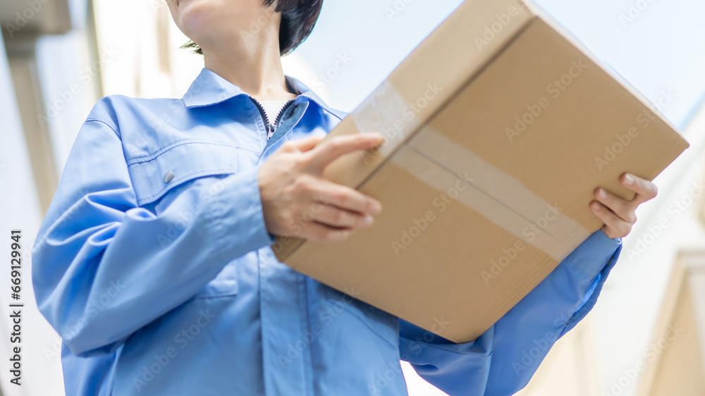 荷物を運ぶ女性　物流ドライバー
