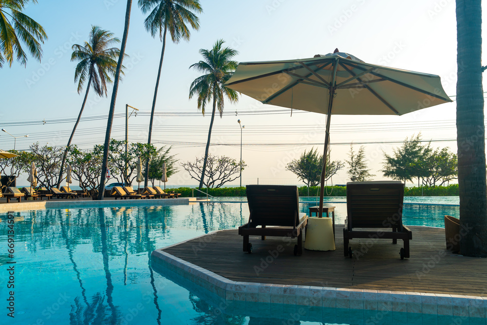 Fototapeta premium umbrella with bed pool around swimming pool with ocean sea background