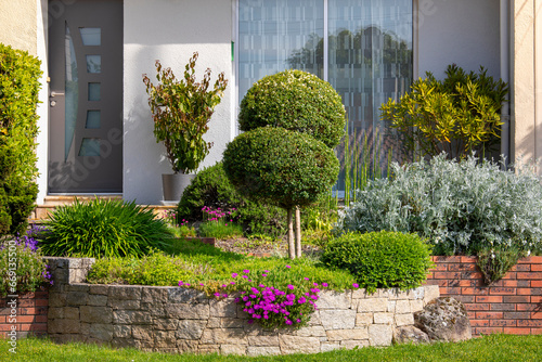 Aménagement de jardin paysagé, plante et fleur au pied d'une maison moderne. photo
