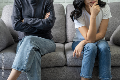 Beautiful Asian lesbian couple is stressed after an argument at home in an irritated mood.