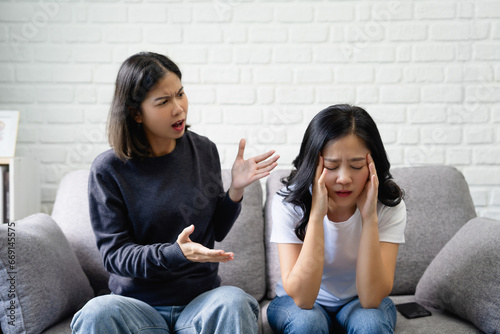 Asian lesbian couple arguing on the sofa photo