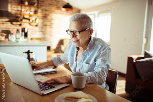 Senior woman working from home and taking notes © Vorda Berge