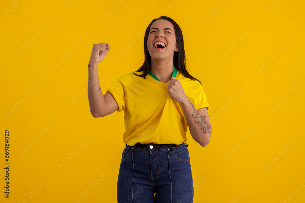 Young beautiful woman in shirt with the yellow color of Brazil in studio photo with various expressions of feelings Young beautiful woman in shirt with the yellow color of Brazil in studio photo with various expressions of feelings