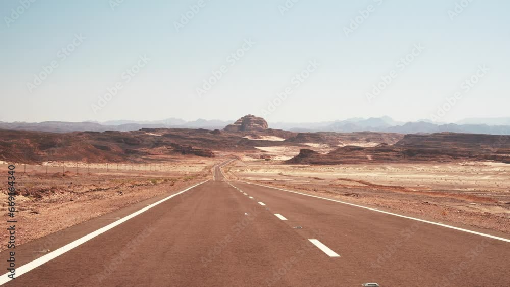 Minibus passing by the empty asphalt road into the distance in the wild desert. Road trip In hot weather Minibus passing by the empty asphalt road into the distance in the wild desert. Road trip In hot weather