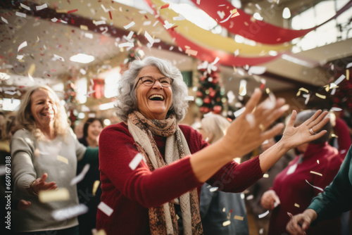 An elderly woman in glasses with gray hair rejoices in a holiday atmosphere with flying confetti