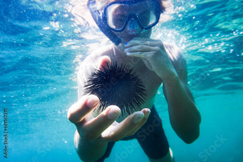 A man with a sea urchin in his hand.