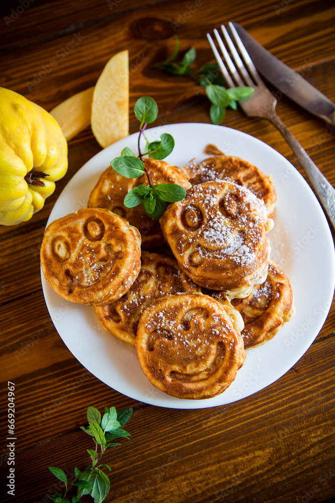 Cooked fried round pancakes with quince filling on a wooden table Cooked fried round pancakes with quince filling on a wooden table
