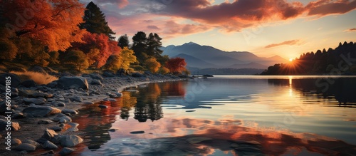 sunset on the lake shore. Mountain views. reflections, reddish sky and yellow sunlight. landscape at sunset. © GoDress