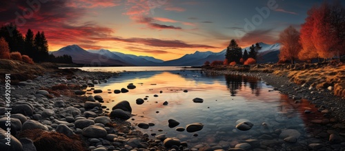 sunset on the lake shore. Mountain views. reflections  reddish sky and yellow sunlight. landscape at sunset.