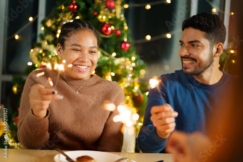 Photography Group of diverse ethnicity young people enjoy celebrating a Christmas and New Year party together with a lot of foods and drinks and enjoy playing with sparkling bengal light - fireworks together