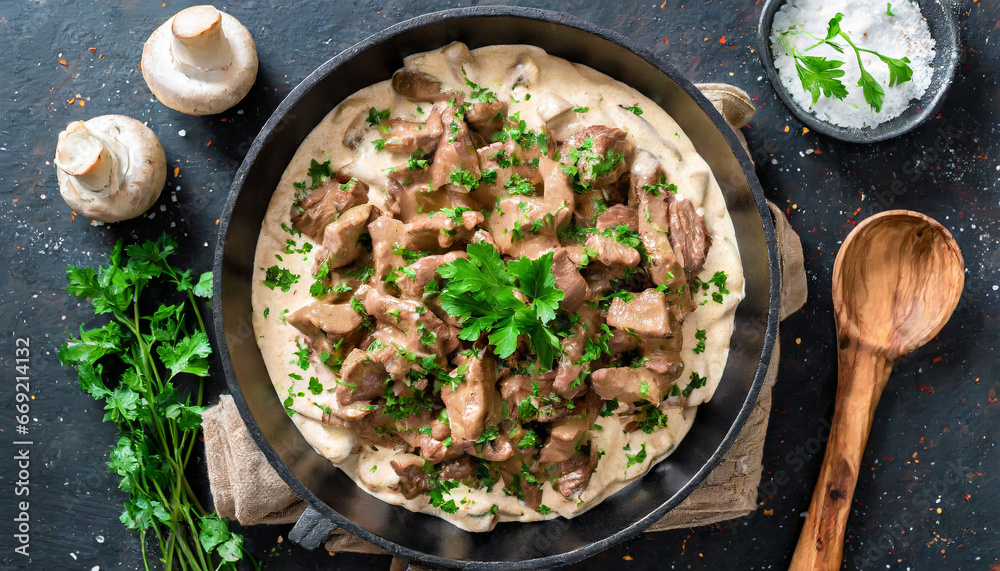 delicious beef stroganoff veal strips stewed with porcini in sour cream sauce sprinkled with finely chopped parsley on skillet authentic recipe view from above delicious beef stroganoff veal strips stewed with porcini in sour cream sauce sprinkled with finely chopped parsley on skillet authentic recipe view from above
