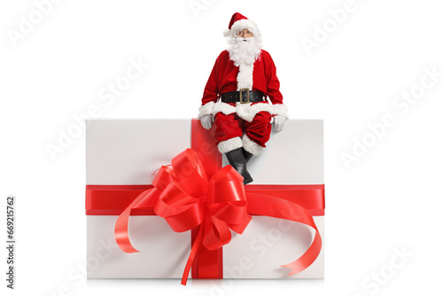 Full length portrait of a santa claus sitting on a big present box
