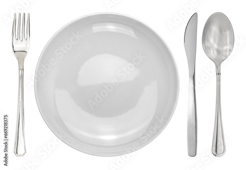 Table setting with a white plate next to cutleries. Plate with fork and knife and spoon isolated