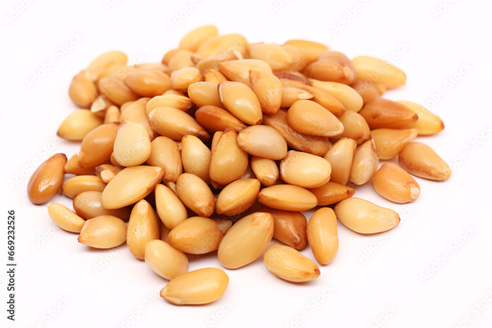 Roasted pine nuts, presented on a white surface, are isolated. Roasted pine nuts, presented on a white surface, are isolated.