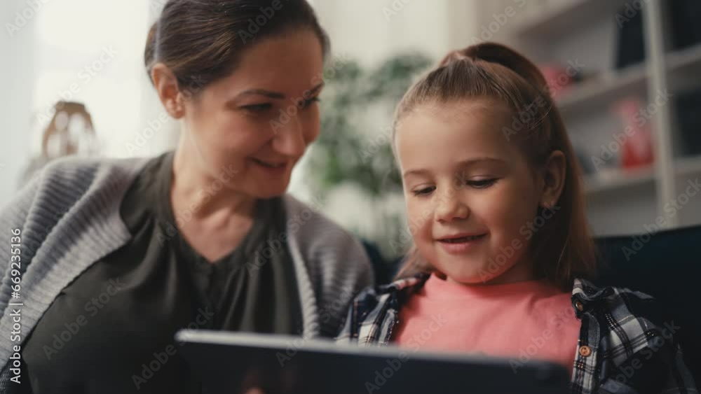 Woman helping daughter to use a new tablet app, trustful relationship, family Woman helping daughter to use a new tablet app, trustful relationship, family