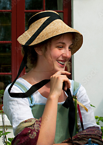 Old-fashioned dressed smiling young girl.