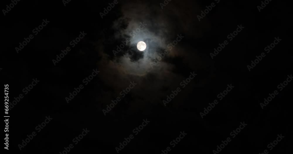 Full moon in the cloudy evening sky, time lapse Full moon in the cloudy evening sky, time lapse