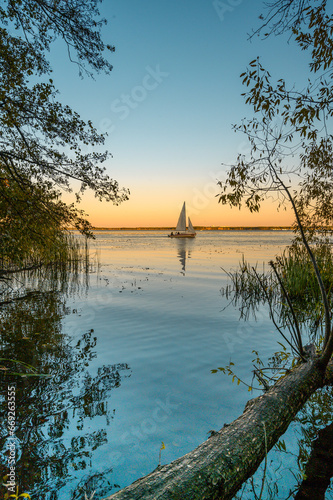 White sailboat on the sunset river