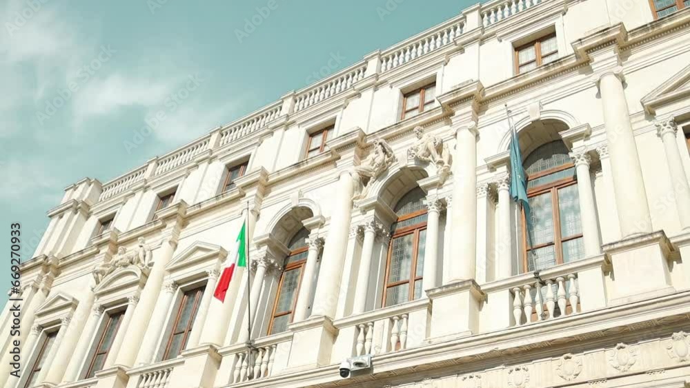 Facade of the building with Italy flag and European Union flags hanging on the facade in the historic center of the town of Bergamo, Italy. Facade of the building with Italy flag and European Union flags hanging on the facade in the historic center of the town of Bergamo, Italy.