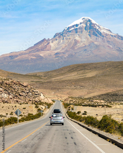 carro trafegando em rodovia com cordilheira dos andes ao fundo, na Bolívia  photo