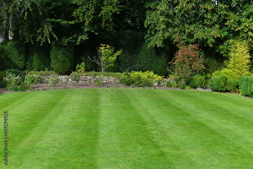 Beautiful garden with a freshly mowed grass lawn photo