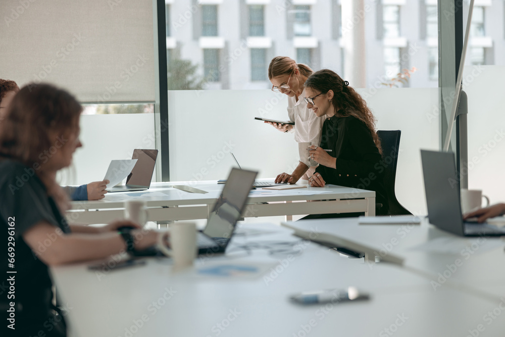 Business people working with laptops in office on colleagues background. Teamwork concept Business people working with laptops in office on colleagues background. Teamwork concept
