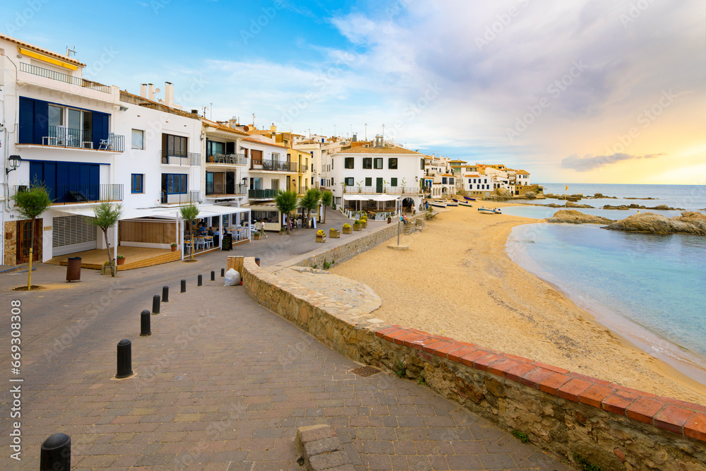 Sandy beach in front of the whitewashed fishing village of Calella de Palafrugell along the Costa Brava coastline of the Girona Province, Southern Spain.