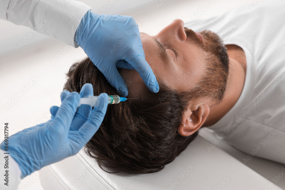 Trichologist giving injection to patient in clinic, closeup Trichologist giving injection to patient in clinic, closeup