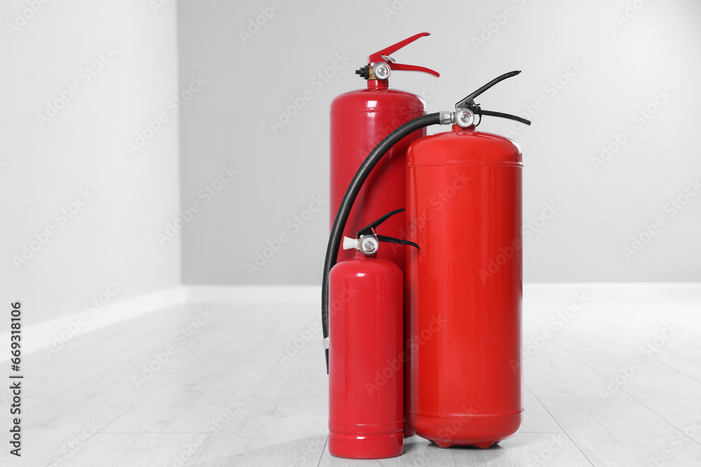 Fire extinguishers on floor indoors, space for text