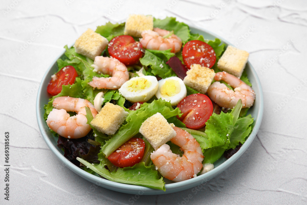 Delicious Caesar salad with shrimps on white textured table, closeup Delicious Caesar salad with shrimps on white textured table, closeup