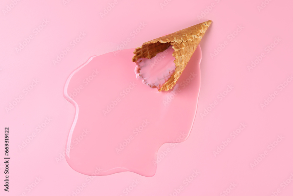 Melted ice cream and wafer cone on pink background, top view. Space for text Melted ice cream and wafer cone on pink background, top view. Space for text