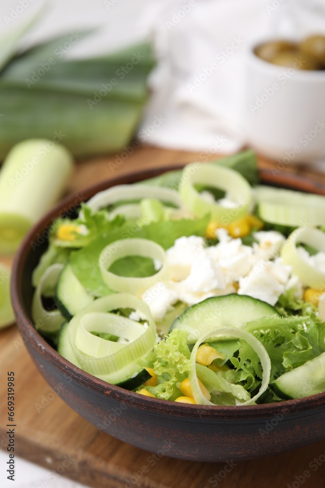 Bowl of tasty salad with leek and cheese on table, closeup Bowl of tasty salad with leek and cheese on table, closeup