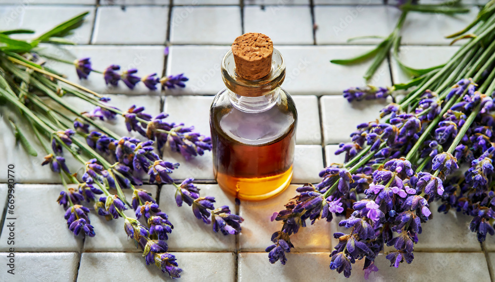 Lavender natural essential oil and fresh lavender on a white tile background.