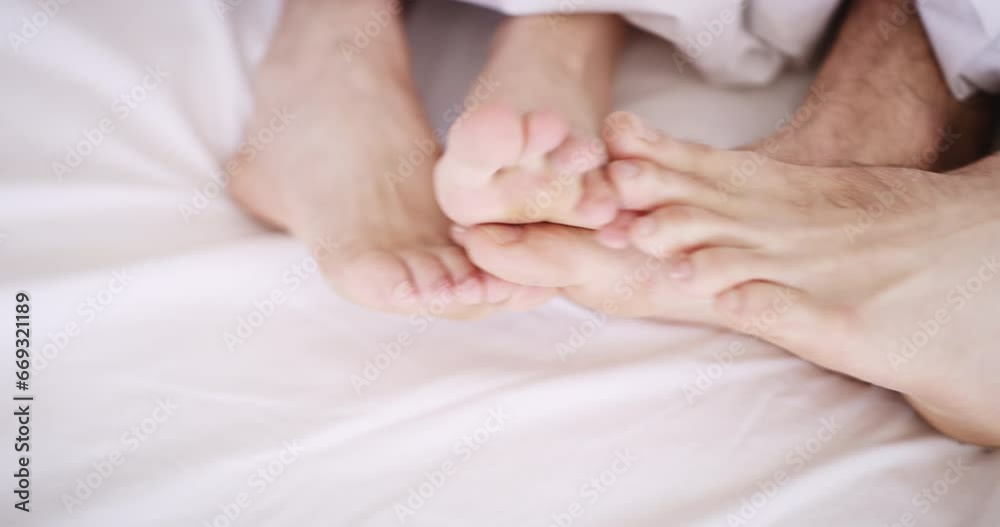 Couple, feet and together for cuddle on bed, sleep or relax in peace for morning in room. Man, woman or love in romance for dating, marriage or relationship for bonding, rest or comfort on weekend