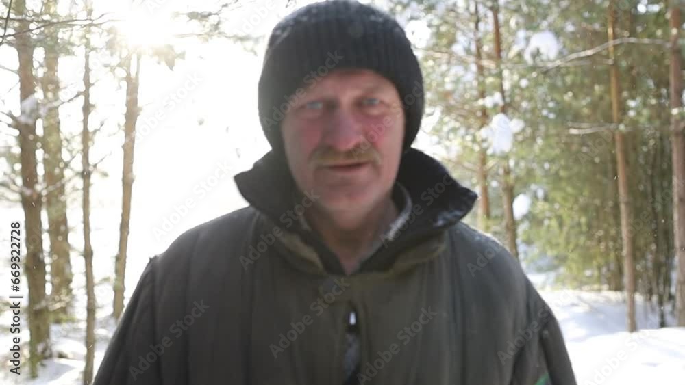 mustachioed man in a quilted jacket walks through the forest in the snow in winter mustachioed man in a quilted jacket walks through the forest in the snow in winter