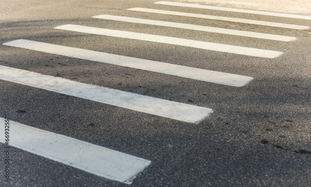 crosswalk on urban street, painted white lines symbolize safety and community, pedestrians crossing, city life, traffic, pedestrian-friendly environment, road safety, walking, urban infrastructure