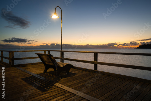 Bank auf der Seebrücke von Gören, Rügen kurz vor Sonnenaufgang bei klaren Himmel