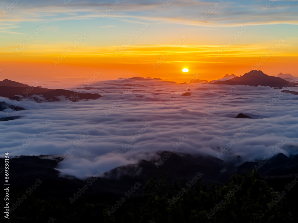 Fototapeta premium Paysage montagneux avec un couché de soleil et une mer de nuage à perte de vu