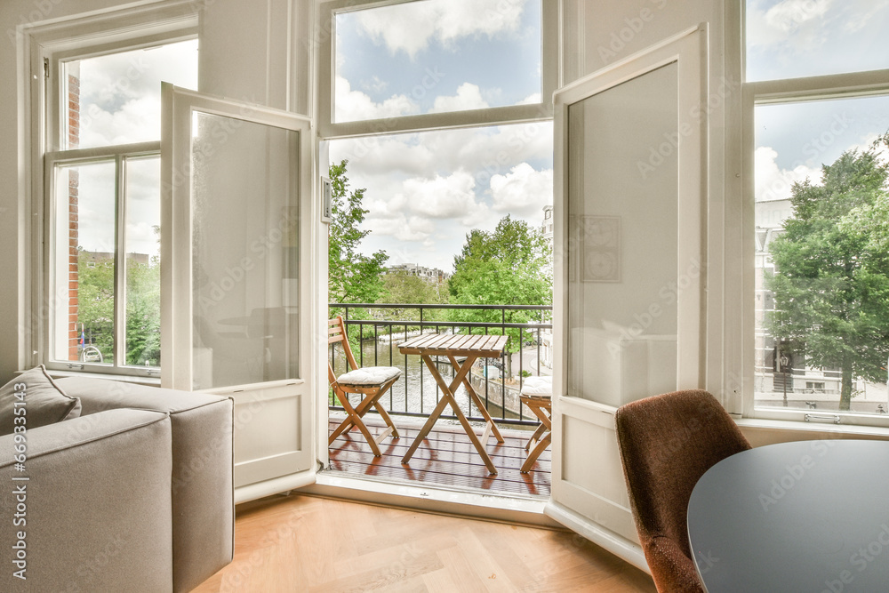 Fototapeta premium a living room with two windows and a table on the floor in front of the window looking out onto the street