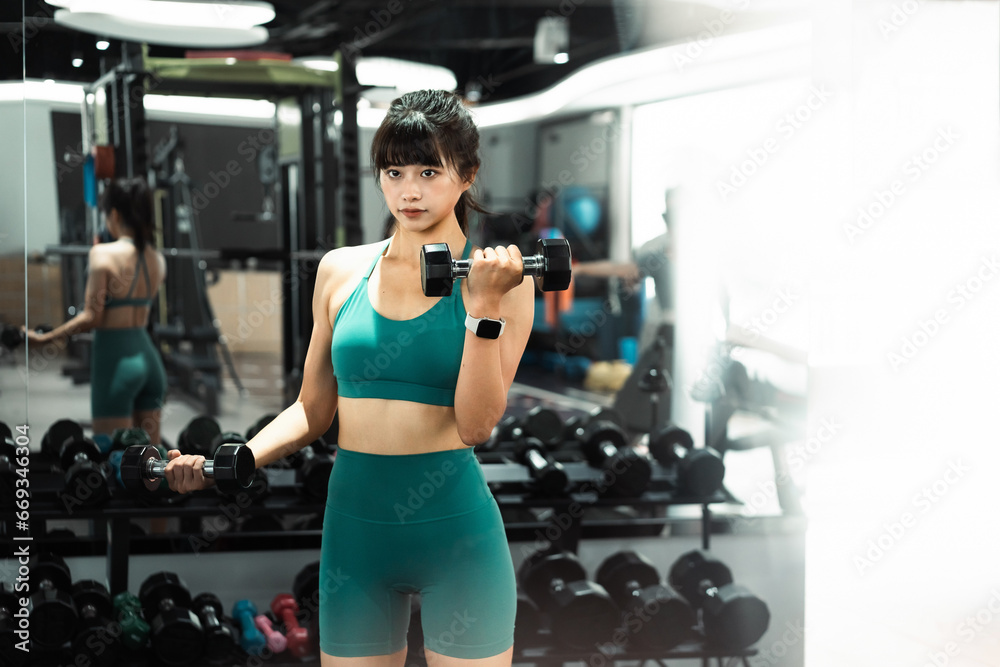 Asian woman exercising with dumbbells in gym. Asian woman exercising with dumbbells in gym.