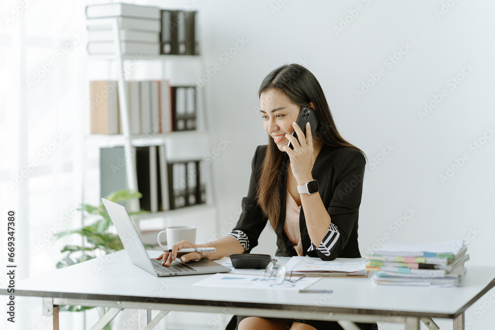 Asian woman sitting at a desk working in the office use a computer, laptop Asian woman sitting at a desk working in the office use a computer, laptop