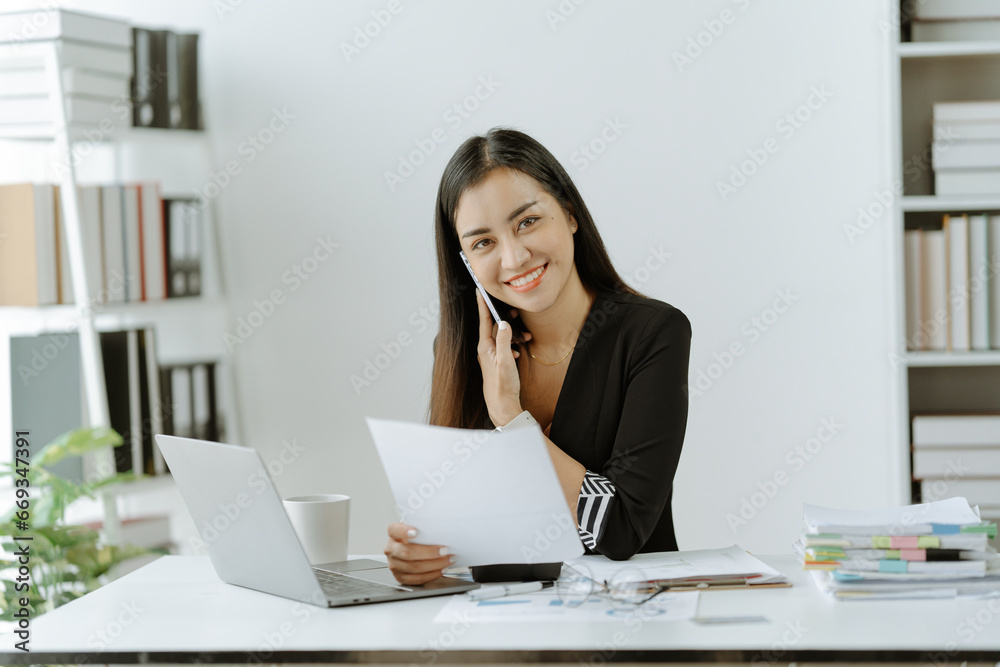 Asian woman sitting at a desk working in the office use a computer, laptop Asian woman sitting at a desk working in the office use a computer, laptop