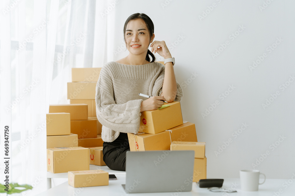 ortrait of a small business startup, SME owner, female entrepreneur, working, unboxing, checking orders online. To prepare to pack boxes for sale to SME customers online business ideas ortrait of a small business startup, SME owner, female entrepreneur, working, unboxing, checking orders online. To prepare to pack boxes for sale to SME customers online business ideas