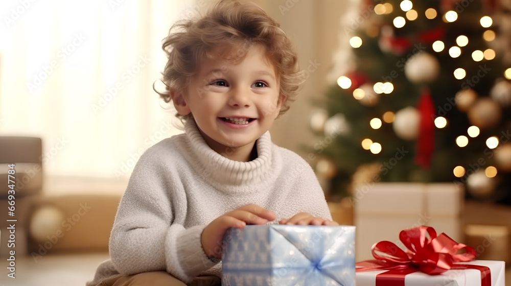 A cute boy opens a gift under the Christmas tree. Happy boy on New Year's Eve. A cute boy opens a gift under the Christmas tree. Happy boy on New Year's Eve.