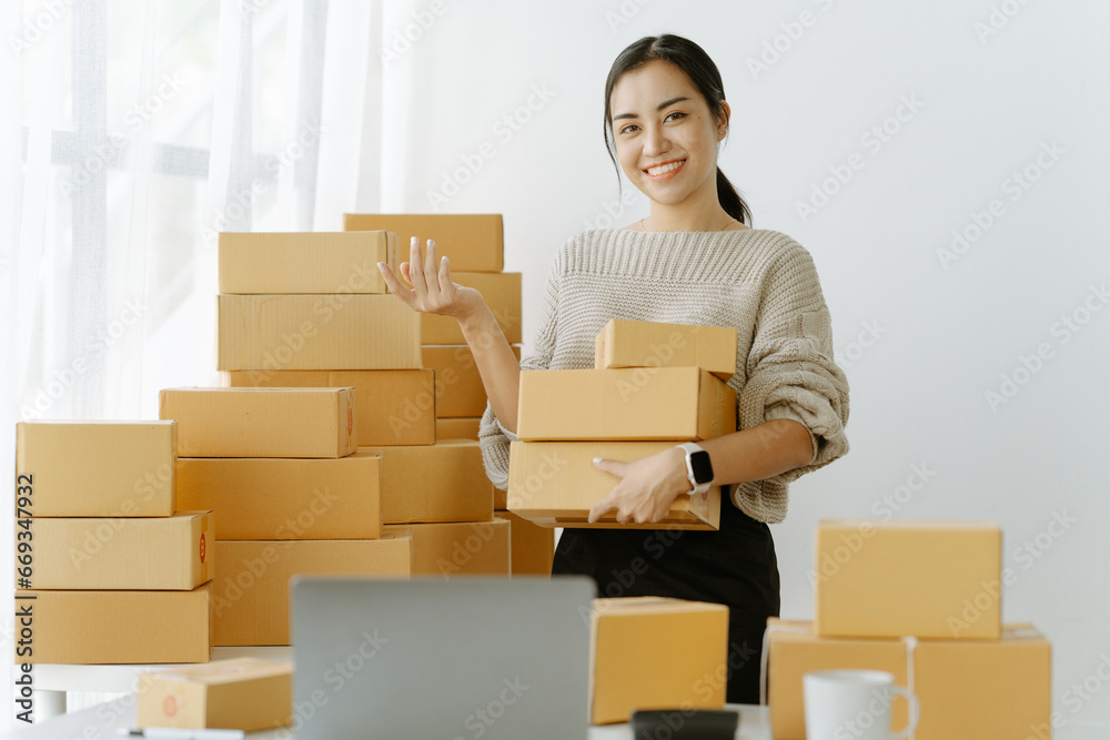 ortrait of a small business startup, SME owner, female entrepreneur, working, unboxing, checking orders online. To prepare to pack boxes for sale to SME customers online business ideas ortrait of a small business startup, SME owner, female entrepreneur, working, unboxing, checking orders online. To prepare to pack boxes for sale to SME customers online business ideas